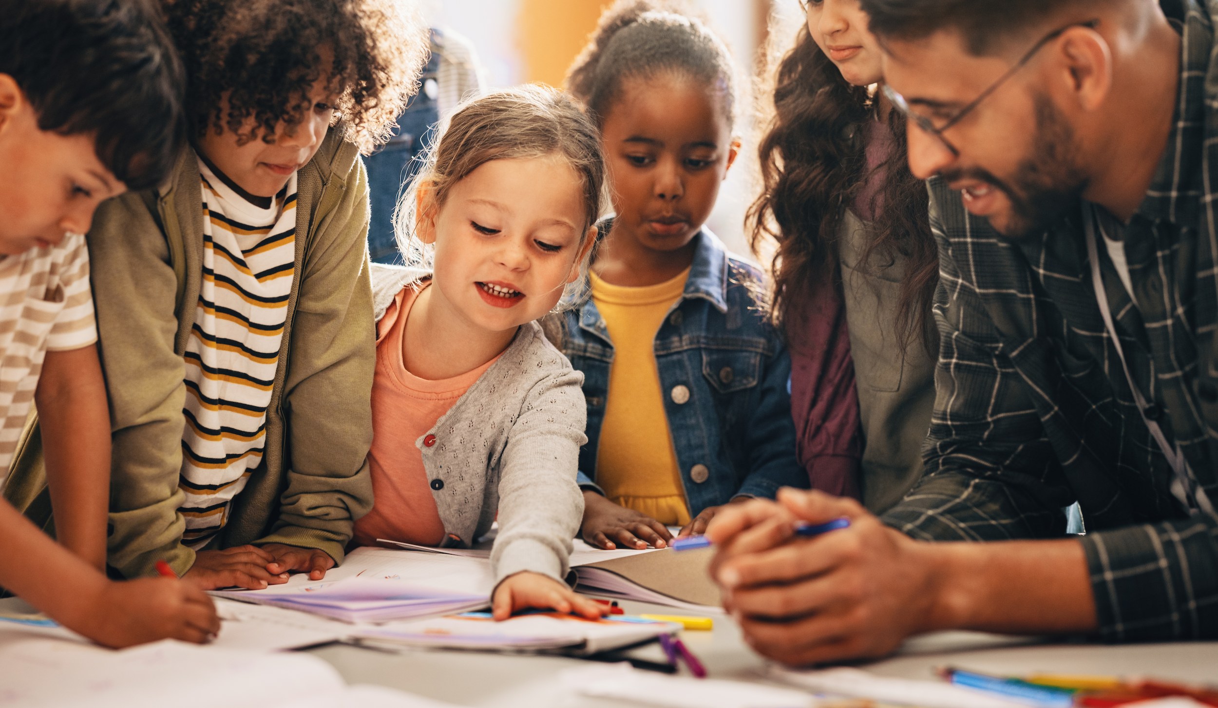 Children learning how to draw with their teacher