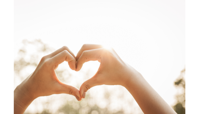 persons hands making the shape of a heart