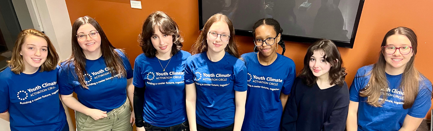 group of young people standing in a line all wearing a blue tshirt