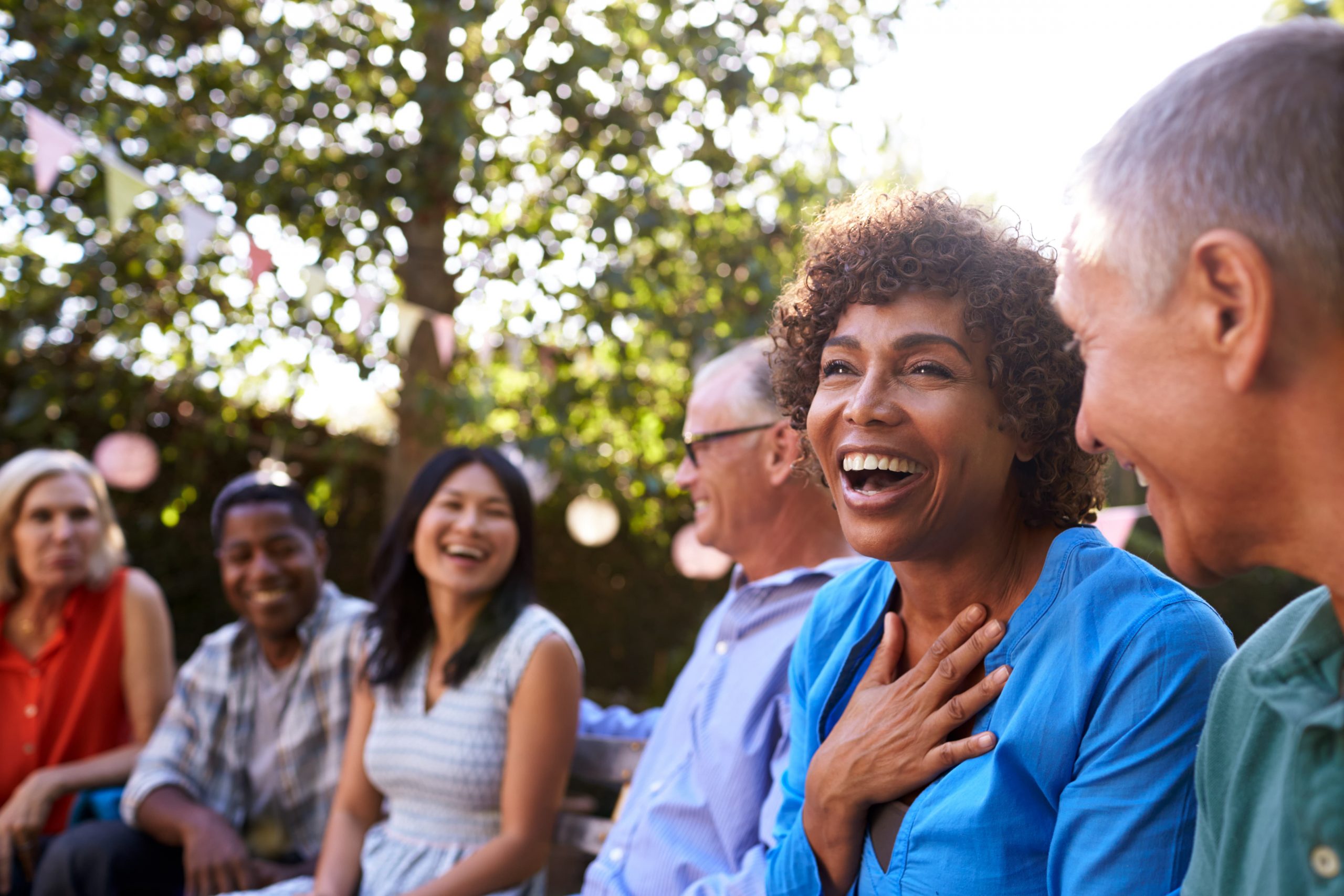 A group of people sit and laugh outside