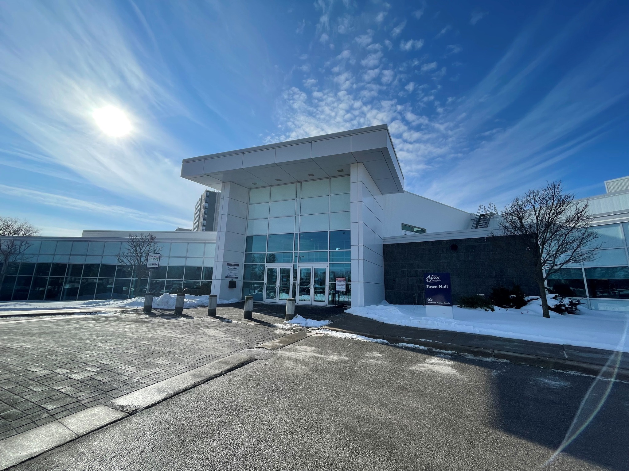 The Town of Ajax Town Hall building on a sunny winter day, with a modern glass entrance and snow on the ground.